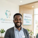 Portrait of David Otieno, a young professional Kenyan man with broad genuine smile in casual office attire