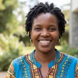 Portrait of Grace Wanjiku, a Kenyan mother smiling warmly with clear healthy teeth outdoors