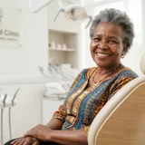 Portrait of Mary Achieng, an older Kenyan grandmother with gentle kind eyes and healthy smile