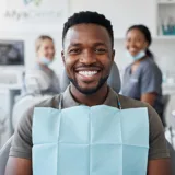 Portrait of a Kenyan man with clean healthy white teeth smiling happily in clinic environment